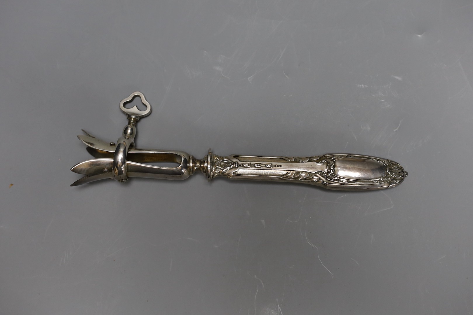 A silver plated ham clamp, cased, 21 cms long.